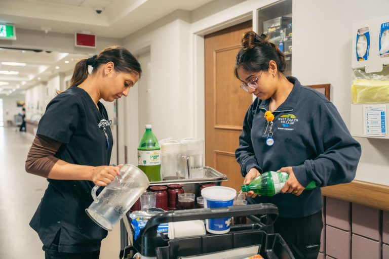 Two staff members preparing drinks at a refreshment cart