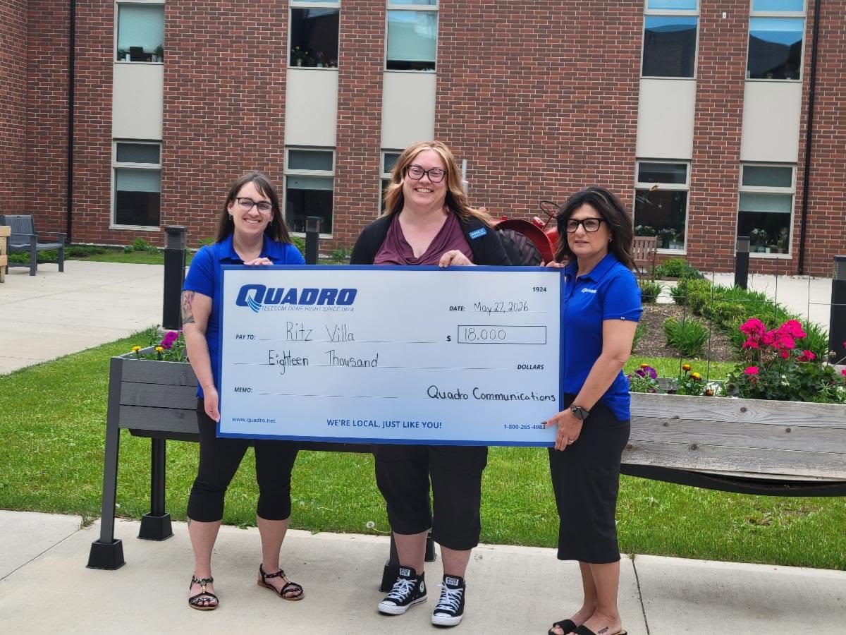 Quadro Communications representatives presenting a cheque at West Perth Village